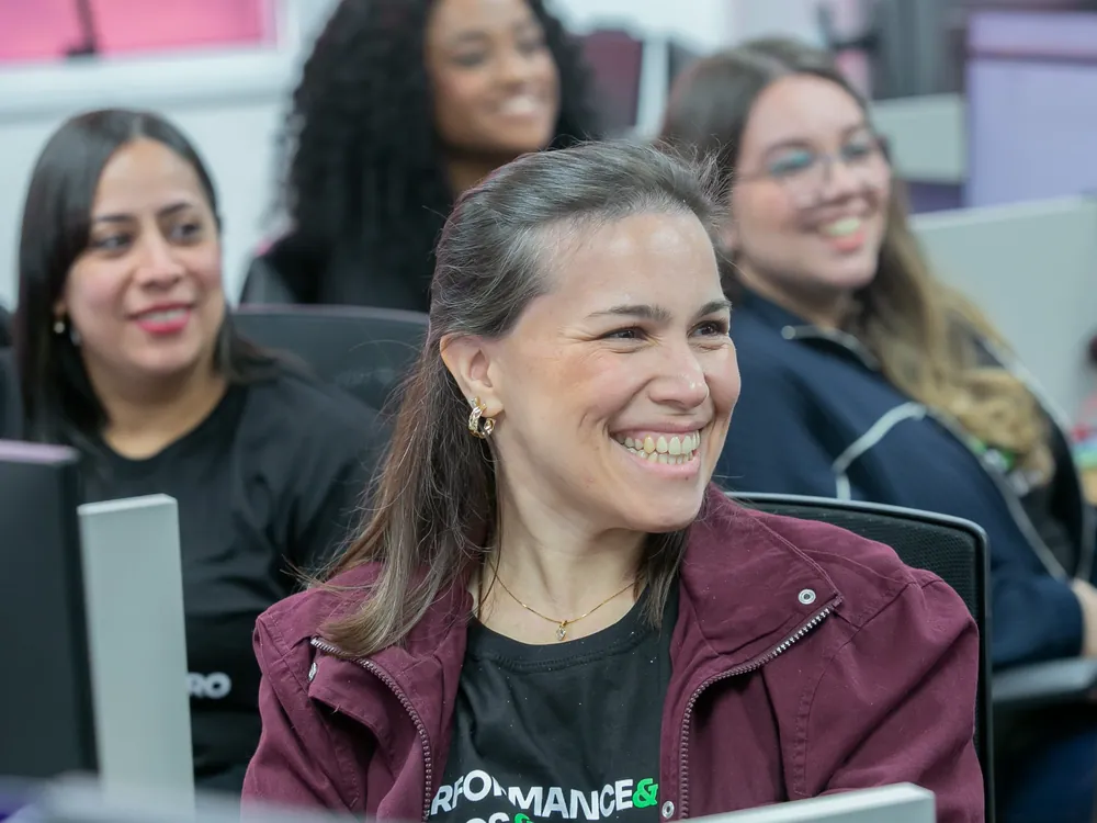 Colaboradoras da Kontrip sorrindo durante encontro no escritório